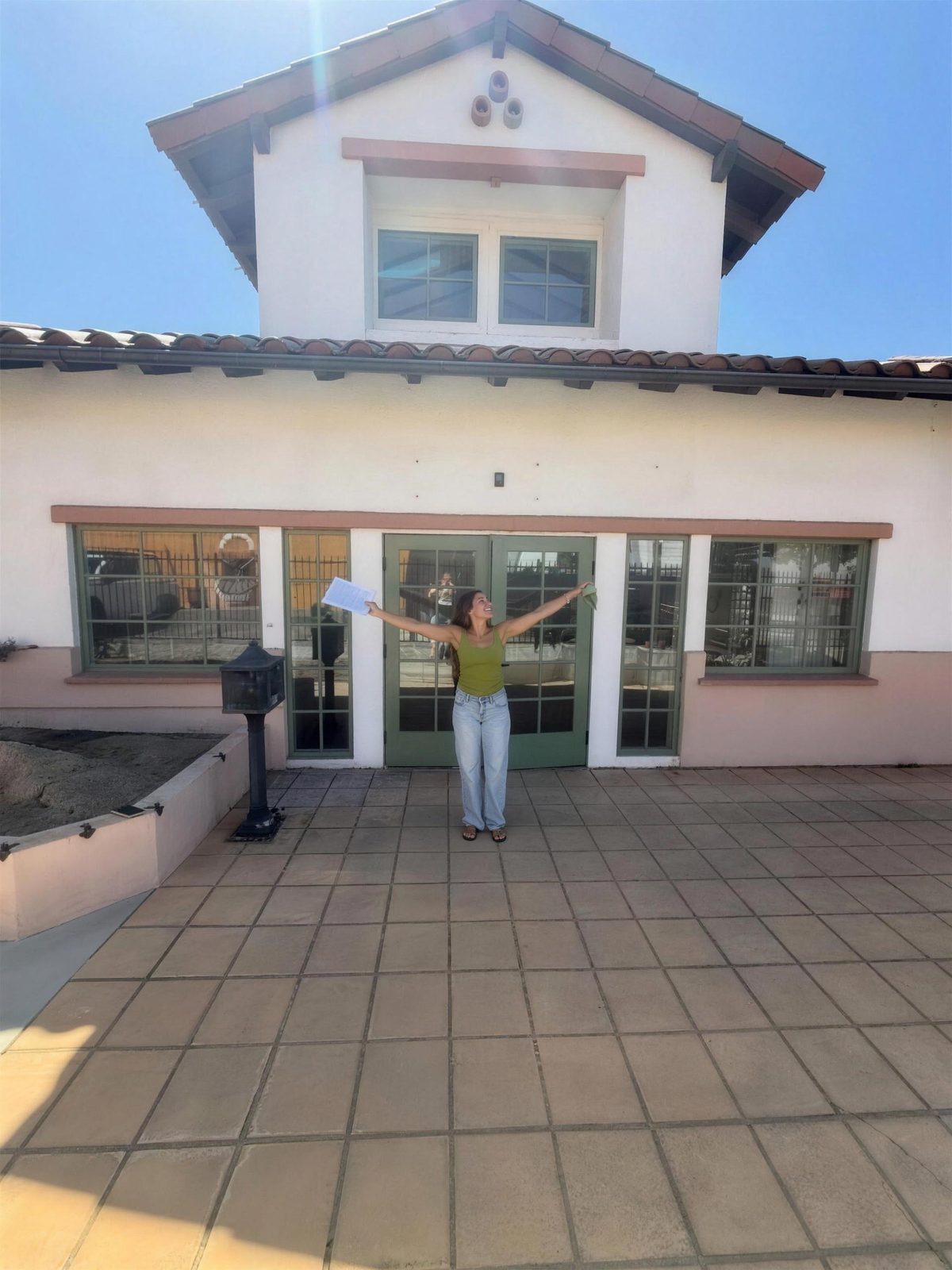 Ahlyssa with her arms open in front of the future Matcha Gusto shop in Santa Paula